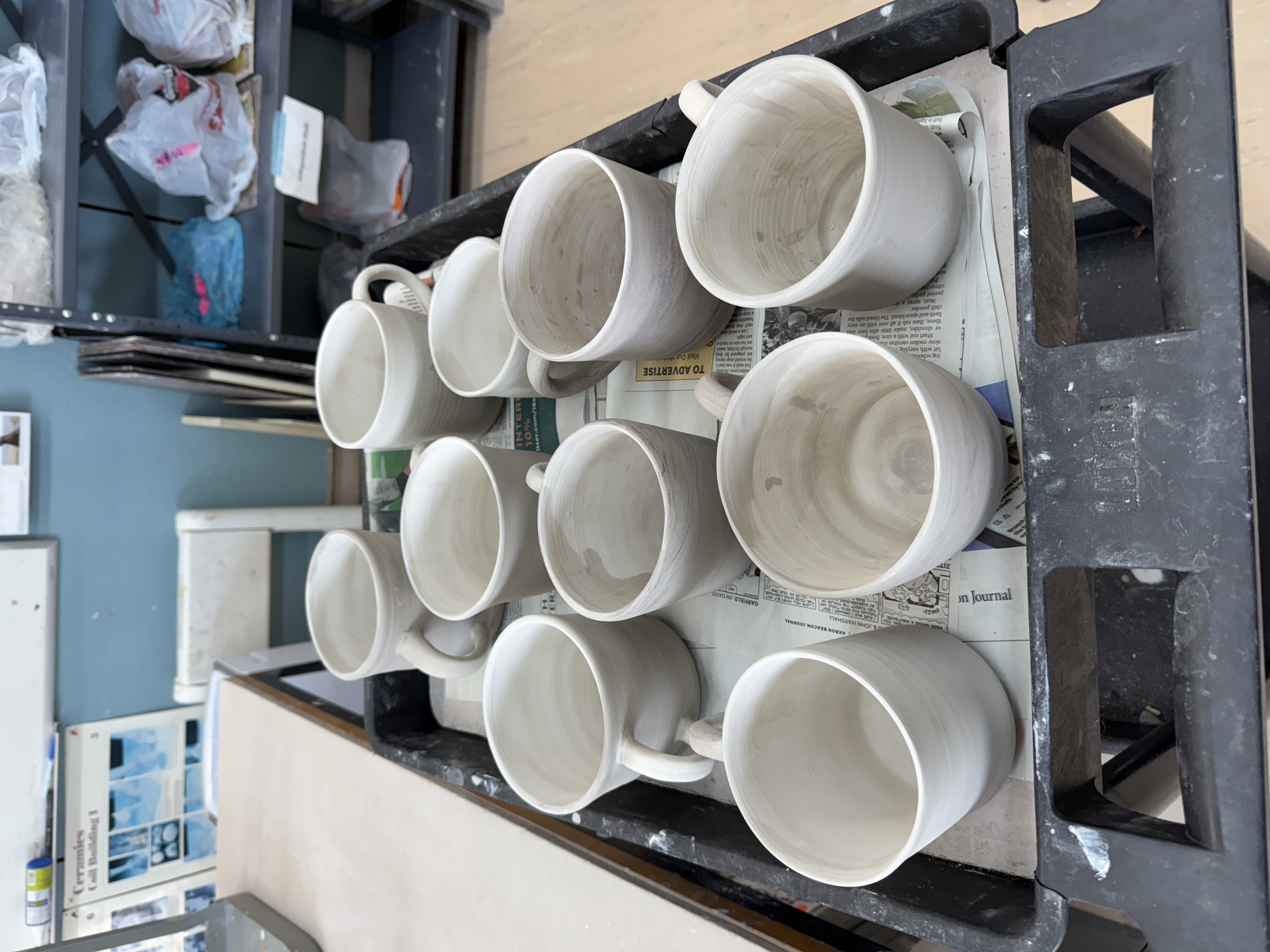 A rack of freshly thrown mugs drying